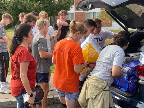 Returning Utica students help new students and families unload their cars at Move-In Day 2022.